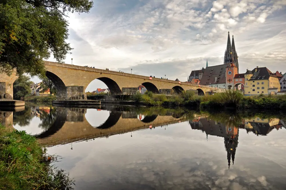 Die Steinerne Brücke und der Regensburger Dom spiegeln sich in der Donau